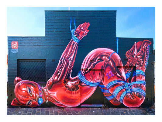 Colorful street art of a figure with red and blue accents on a building.