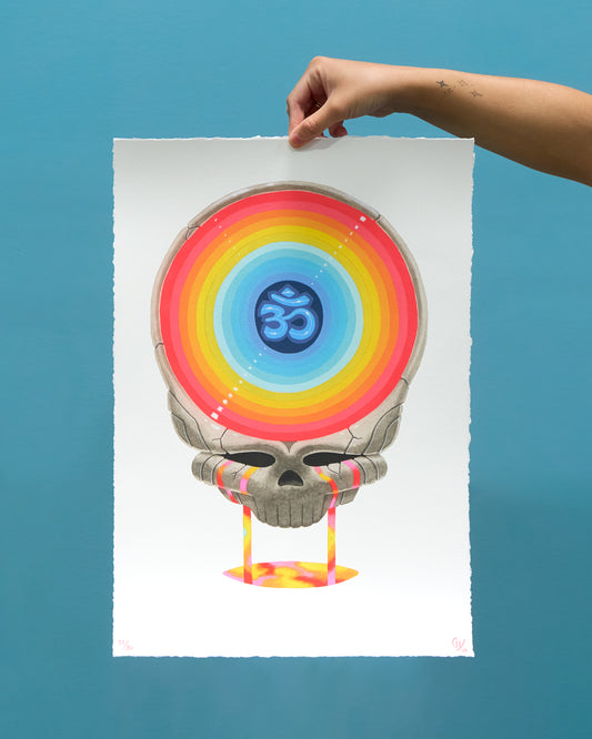 Colorful skull with rainbow design and Om symbol held against a blue background
